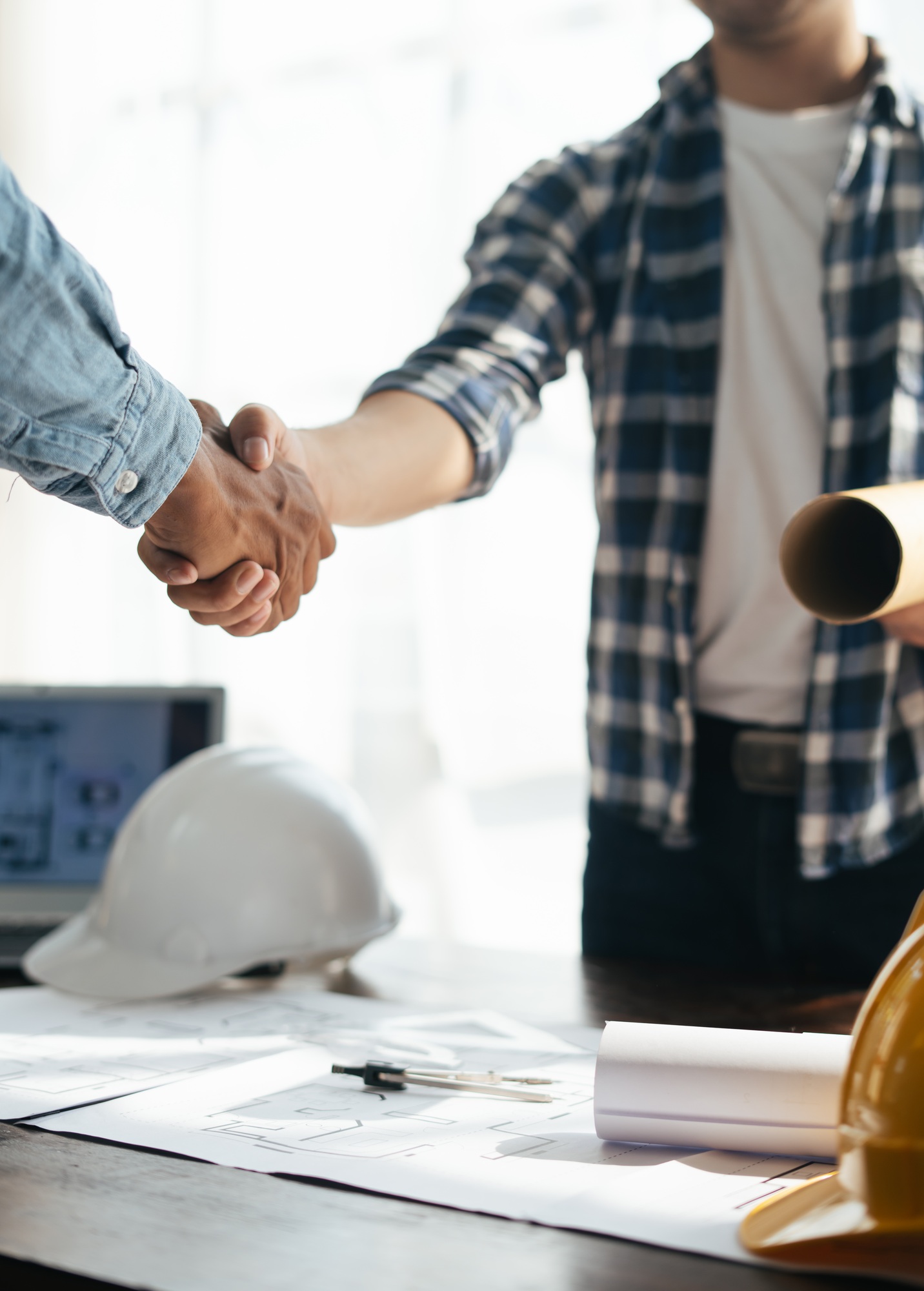Close up view of engineering team shaking hands after the deal is completed. Team planning for archi