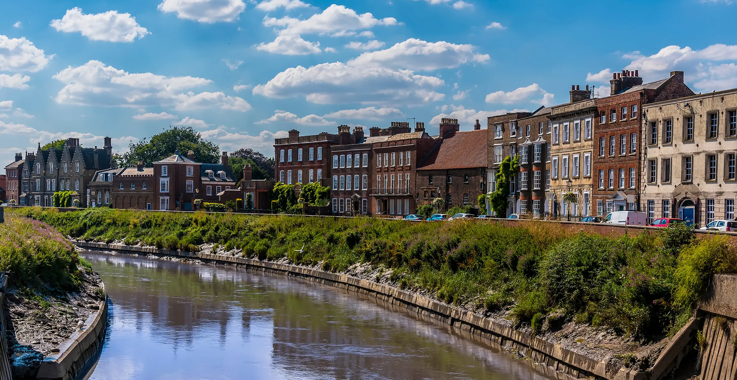 A view across the River Nene towards the North Brink in Wisbech, Cambridgeshire in the summertime