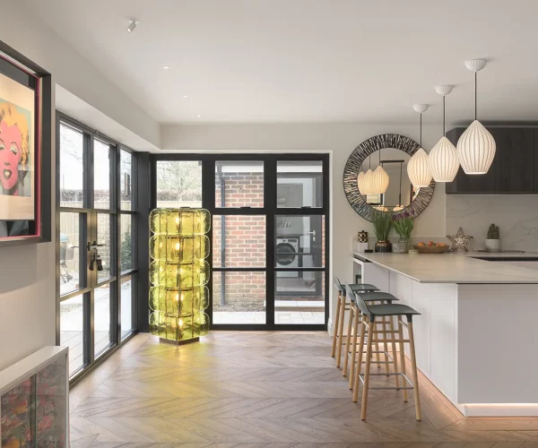 Contemporary lighting frames the space between the kitchen and outdoor entertainment space